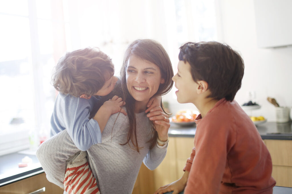 A mom hugging her sons in the kitchen